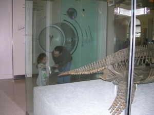 Peo and Daddy beside a plesiosaur.