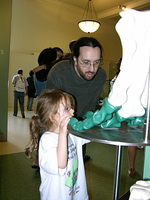 Peo and Daddy read about the three-toed foot and look at the model.